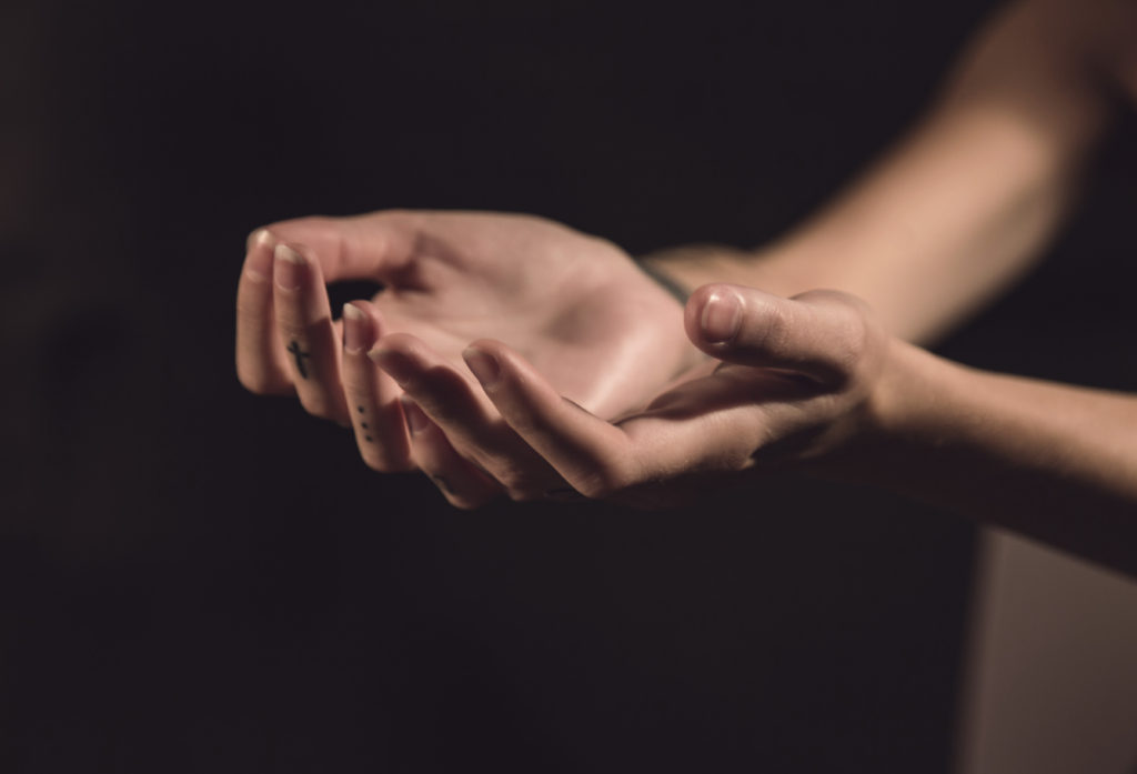 Open hands with cross on one finger and three dots on another