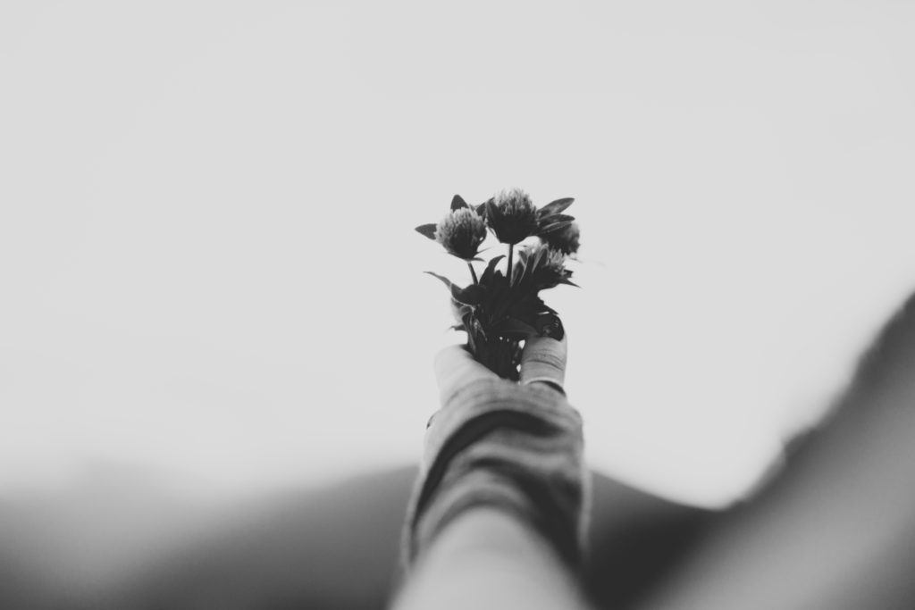 Hand offering flowers