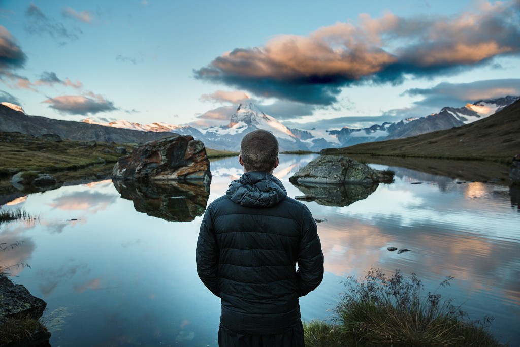 Person facing away looking out over a lake