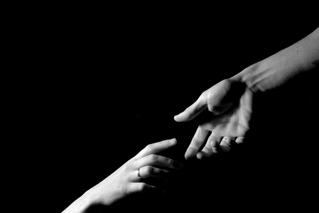 Two Hands Reaching Out To One Another