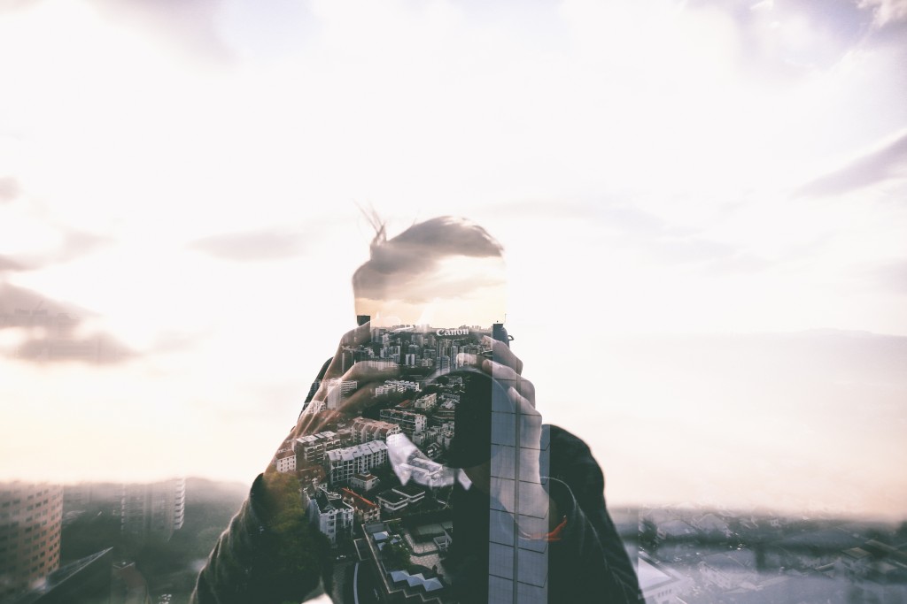 Silhouette of Photographer filled in with images and buildings.